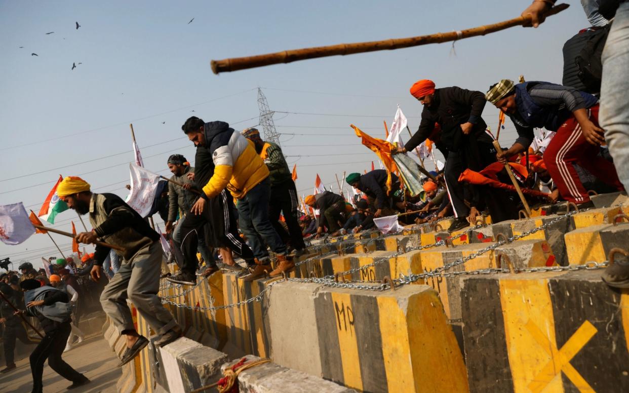 Farmers cross a barricade during a tractor rally to protest against farm laws on the occasion of India's Republic Day in Delhi, India - DANISH SIDDIQUI /REUTERS