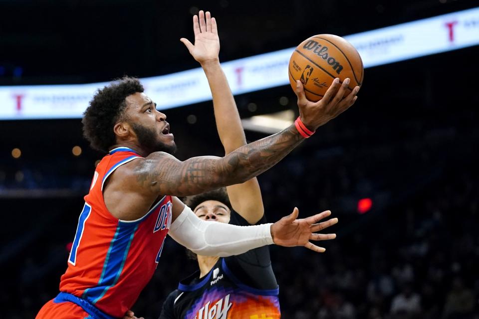 Detroit Pistons forward Saddiq Bey, left, gets off a shot as Phoenix Suns forward Cameron Johnson defends during the first half of an NBA basketball game Thursday, Dec. 2, 2021, in Phoenix. (AP Photo/Ross D. Franklin)