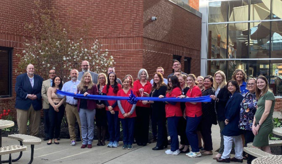 NEC President Wayne Lesperance, far left, joins nursing students and Portsmouth Regional Hospital staff at the ribbon-cutting celebrating the hospital’s cohort of 20 NEC nursing students who begin their clinical experiences in May.