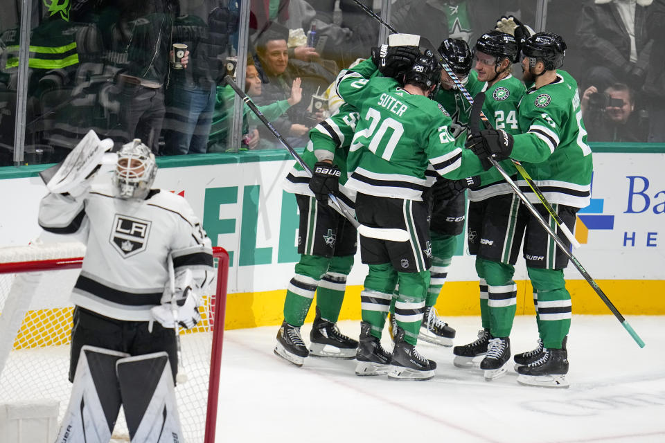 Dallas Stars players, right, celebrate a goal by center Wyatt Johnston (53) as Los Angeles Kings goaltender Cam Talbot, left, looks on during the third period of an NHL hockey game, Tuesday, Jan. 16, 2024, in Dallas. The Stars won 5-1. (AP Photo/Julio Cortez)