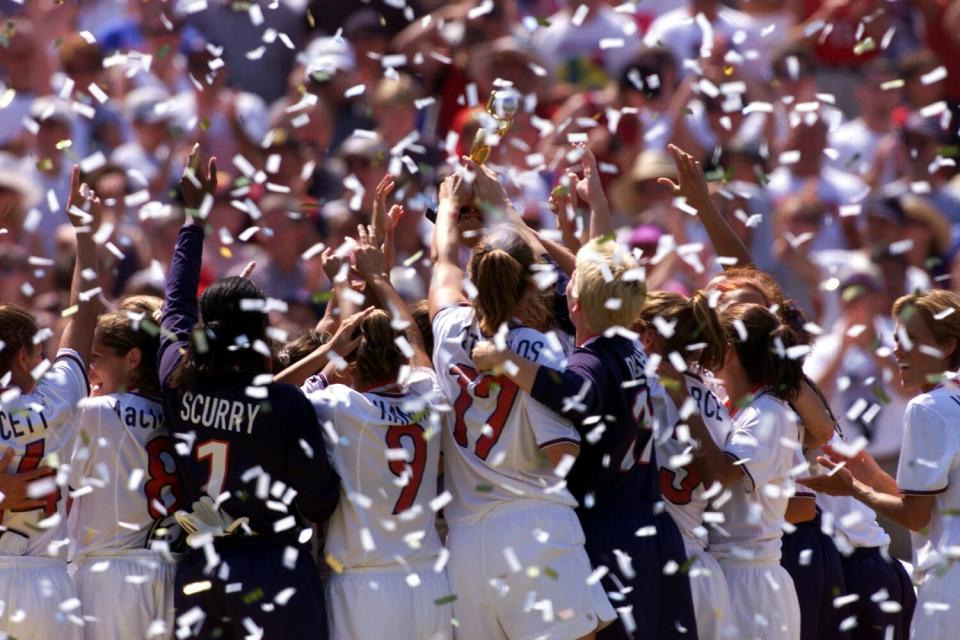 Confetti fills the air as people raise their arms.