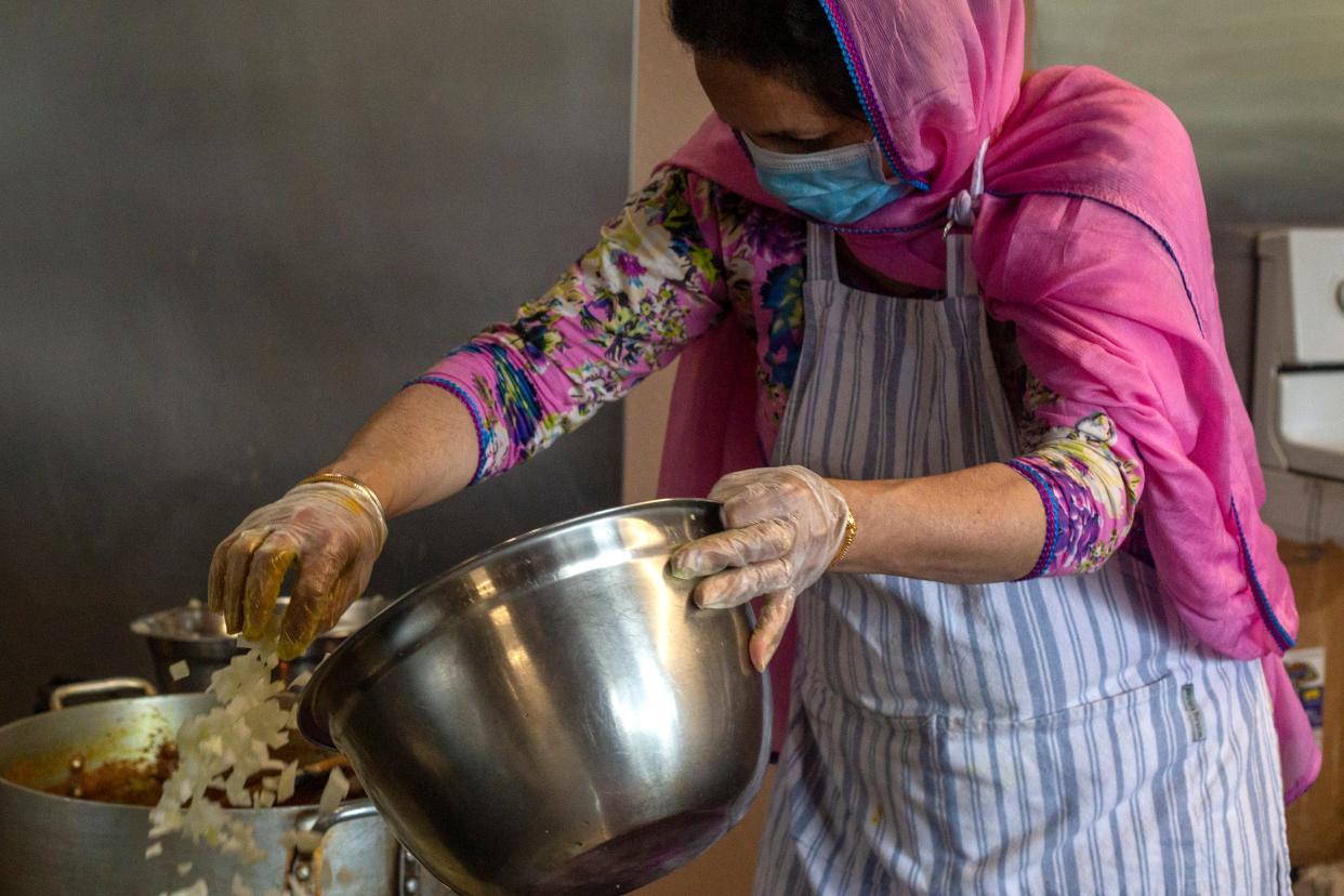 Narinder Kaur adds onion to a dish at the Gurdwara Dasmesh Darbar in Salem, on April 30, 2020. Over 1,000 meals have been prepared and delivered by the Sikh temple community to Salem Hospital employees during COVID-19.