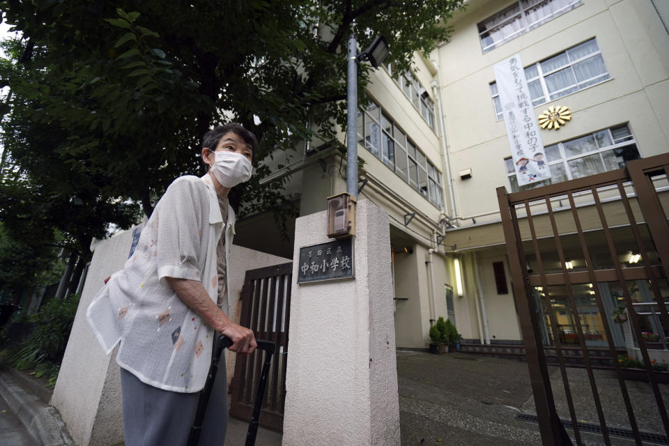 Mitsuyo Hoshino, 86, who lost her parents and siblings to the Great Tokyo Air Raid on March 10, 1945, stands in front of Chuwa Elementary School, the school she was attending then, in Tokyo Tuesday, July 28, 2020. In Japan, war orphans were punished for surviving. They were bullied. They were called trash, sometimes rounded up by police and put in cages. Some were sent to institutions or sold for labor. They were targets of abuse and discrimination. Now, 75 years after the war's end, some are revealing their untold stories of recovery and pain, underscoring Japan’s failure to help its own people. (AP Photo/Eugene Hoshiko)