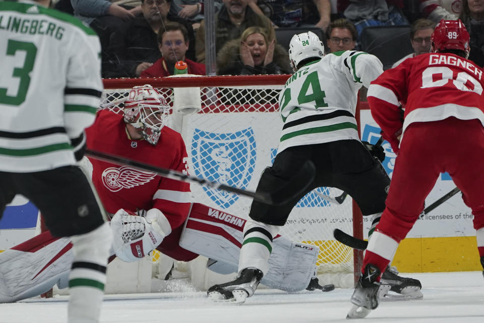 Dallas Stars left wing Roope Hintz (24) scores on Detroit Red Wings goaltender Alex Nedeljkovic (39) during overtime in an NHL hockey game Friday, Jan. 21, 2022, in Detroit. The Stars won 5-4. (AP Photo/Paul Sancya)