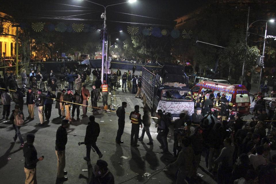 Police and security officers cordon off the area of a deadly bombing, in Lahore, Pakistan, Monday, Feb. 13, 2017. Pakistani police say a large bomb has struck a protest rally in the eastern city of Lahore, killing many people and wounding others. A local police official said the blast occurred when a man on a motorcycle rammed into the crowd of hundreds of pharmacists, who were protesting new amendments to a law governing drug sales. (AP Photo/K.M. Chaudhry)