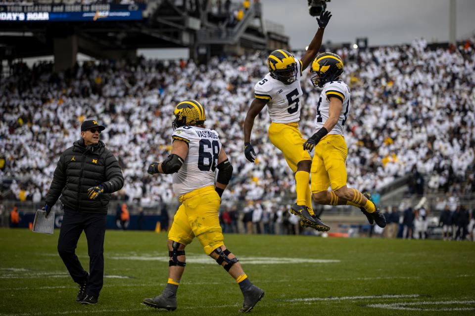 Roman Wilson (14) celebrates his touchdown with Mike Sainristil (5) during the second half at Penn State.