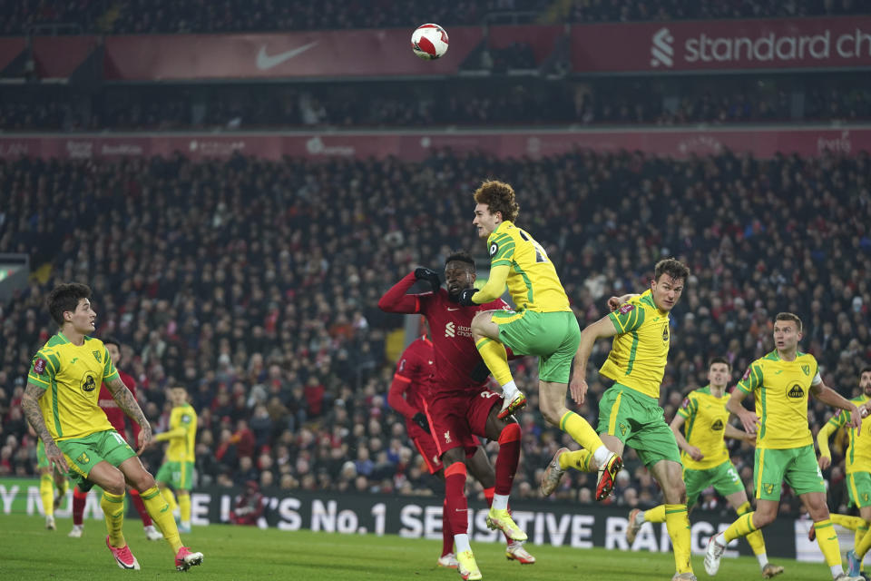 Norwich City's Josh Sargent, center, jumps for the ball with Liverpool's Divock Origi during the English FA Cup soccer match between Liverpool and Norwich City at Anfield stadium in Liverpool, England, Wednesday, March 2, 2022. (AP Photo/Jon Super)