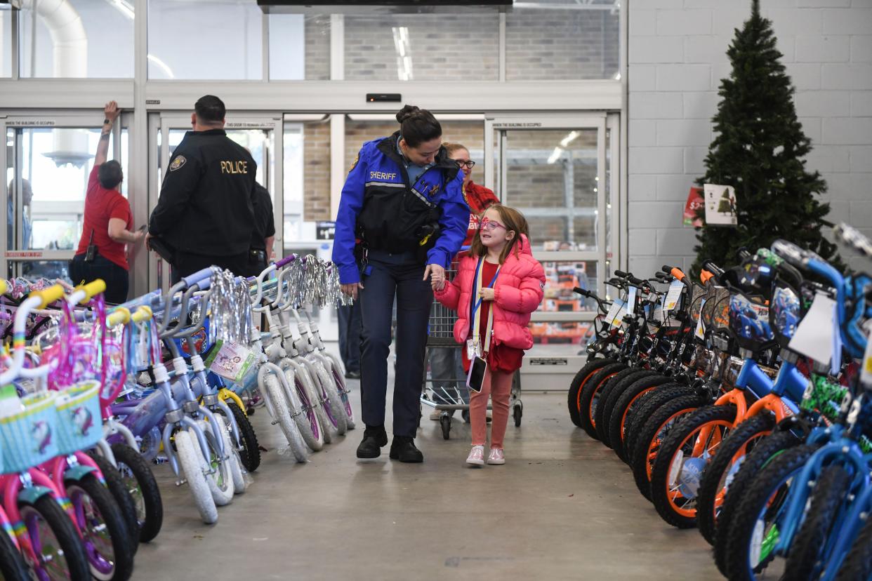 Claire Lee, 6, walks in with her deputy during the Columbia County Sheriff's Office Day with a Deputy at Walmart on Thursday, Dec. 21, 2023.