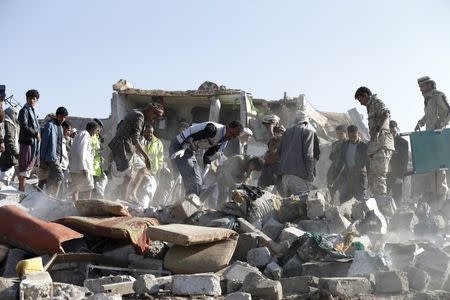 Civil defence workers and people search for survivors under the rubble of houses destroyed by an air strike near Sanaa Airport March 26, 2015. REUTERS/Khaled Abdullah