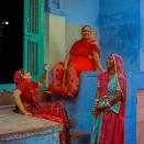 <p>Indian neighbours Sharda (L), 45, Sopa (C), 52, and Kosholi, 50, talk on steps outside their homes in Jodhpur on March 18, 2016. Rajasthan’s ‘Blue City’ Jodhpur is famed for the blue-painted walls of the old city that sits in the shadow of the Mehrangarh Fort. Used to denote Brahmin, or upper-caste, households, discouraging looters if the city ever came under attack, many of Jodhpurs buildings retain the traditional blue paintwork that has come to signify the city. </p>