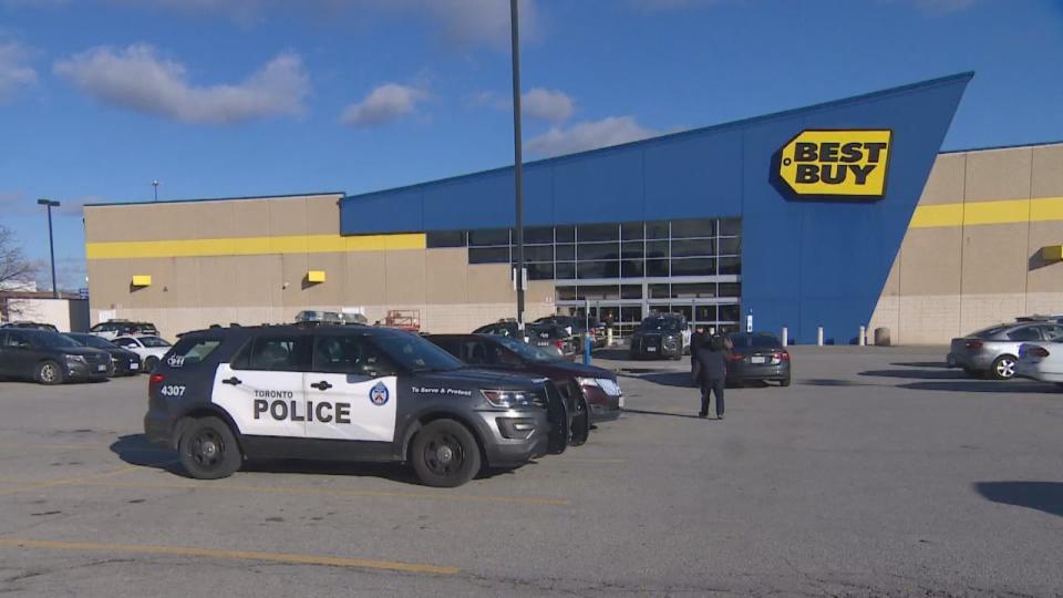 A Toronto police vehicle is parked outside a store in Scarborough after an off-duty officer was stabbed in the wrist on Wednesday. (CBC - image credit)