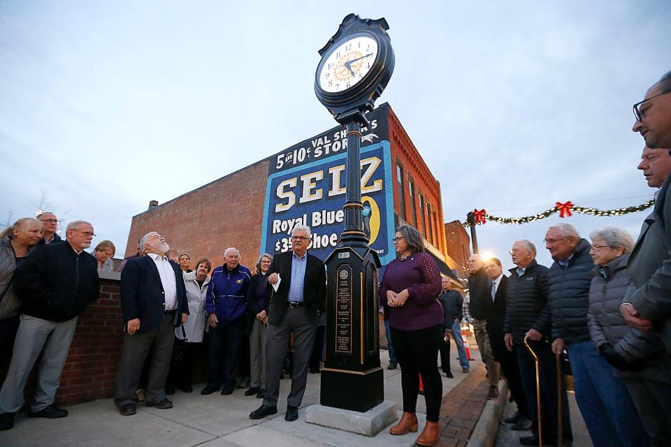 Rotary Club of Ashland past President Ted Daniels, left of the clock, speaks along with President Stacy Schiemann, right, at a dedication ceremony. The Rotary Club has an endowment fund with the Ashland County Community Foundation the city can use for clock maintenance.