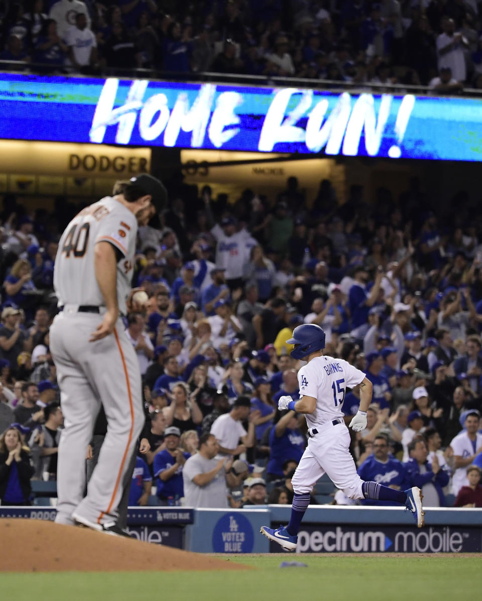 Los Angeles Dodgers' Austin Barnes, right, rounds third after hitting a two-run home run off San Francisco Giants starting pitcher Madison Bumgarner, left, during the fourth inning of a baseball game Thursday, June 20, 2019, in Los Angeles. (AP Photo/Mark J. Terrill)
