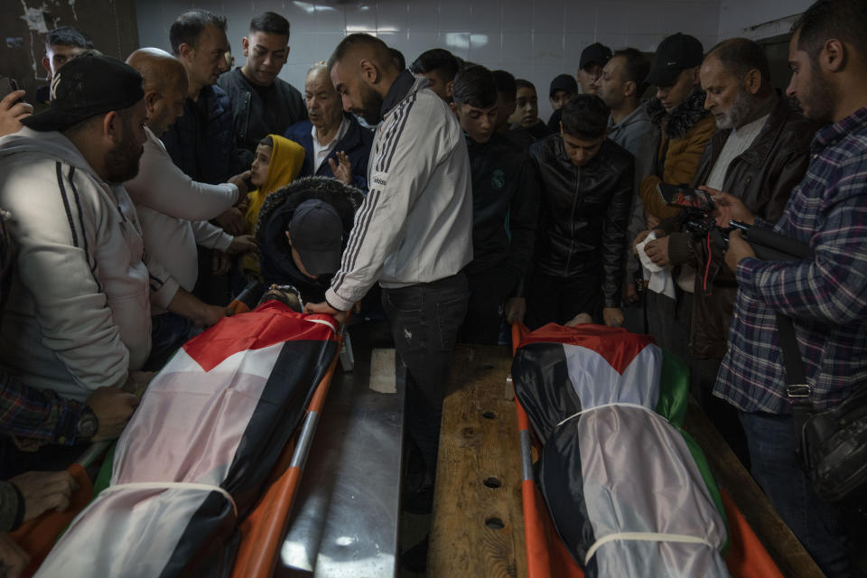 Mourners take a last look at the bodies of Mohammad Herzallah, 30, left and Mohammad Abu Kushuk, 22, in the morgue of Rafeedya Hospital prior to their funeral in the West Bank city of Nablus, Thursday, Nov. 24, 2022. The two Palestinians succumbed to their wounds sustained during clashes with Israeli army forces during military operations in the occupied West Bank. (AP Photo/Nasser Nasser)