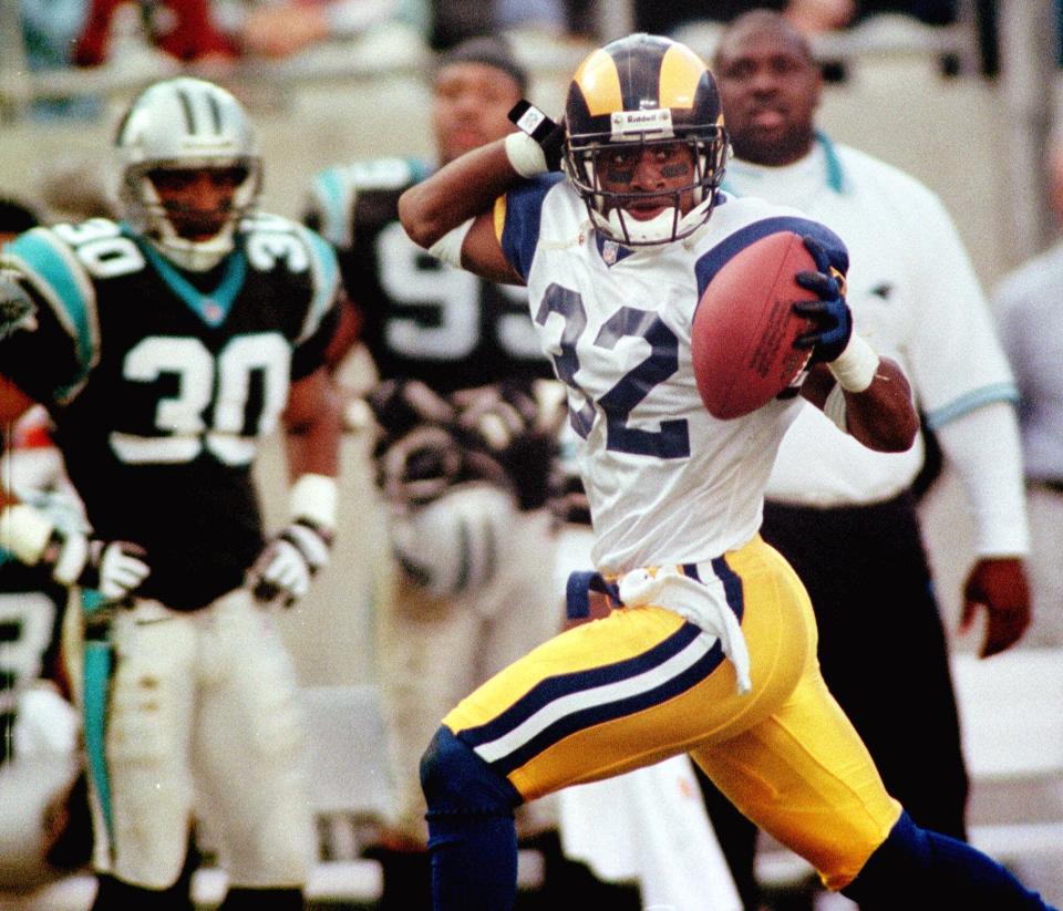 St. Louis Rams' Dre Bly (32) celebrates as he gallops past the Carolina Panthers' bench into the end zone after intercepting a pass in the Rams' 34-21 win at Ericsson Stadium in Charlotte, N.C., Sunday, Dec. 5, 1999. Bly's 53-yard touchdown sealed the game for the Rams.  (AP Photo/Rick Havner)