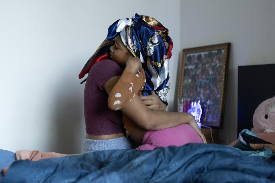 Johnae Strong wakes her 6-year-old daughter Jari Alim as they ready for school and work Friday, Feb. 10, 2023, in Chicago. (AP Photo/Erin Hooley)