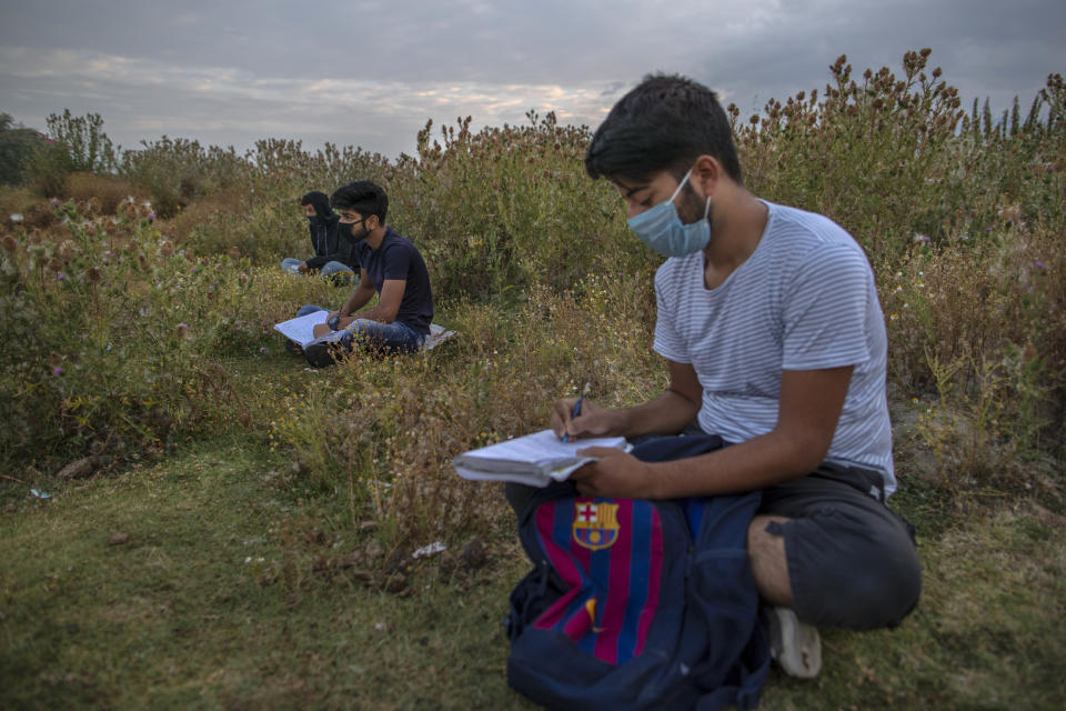 Kashmiri students attend an open-air early morning classes inside Eidgah or ground reserved for Eid prayers in Srinagar, Indian controlled Kashmir, Friday, July 18, 2020. When months went by without teaching, Muneer Alam, an engineer-turned-math teacher, started the informal community school in the form of an open-air classroom in June. Schools in the disputed region reopened after six months in late February, after a strict lockdown that began in August 2019, when India scrapped the region’s semi-autonomous status. In March schools were shut again because of the coronavirus pandemic. (AP Photo/Dar Yasin)