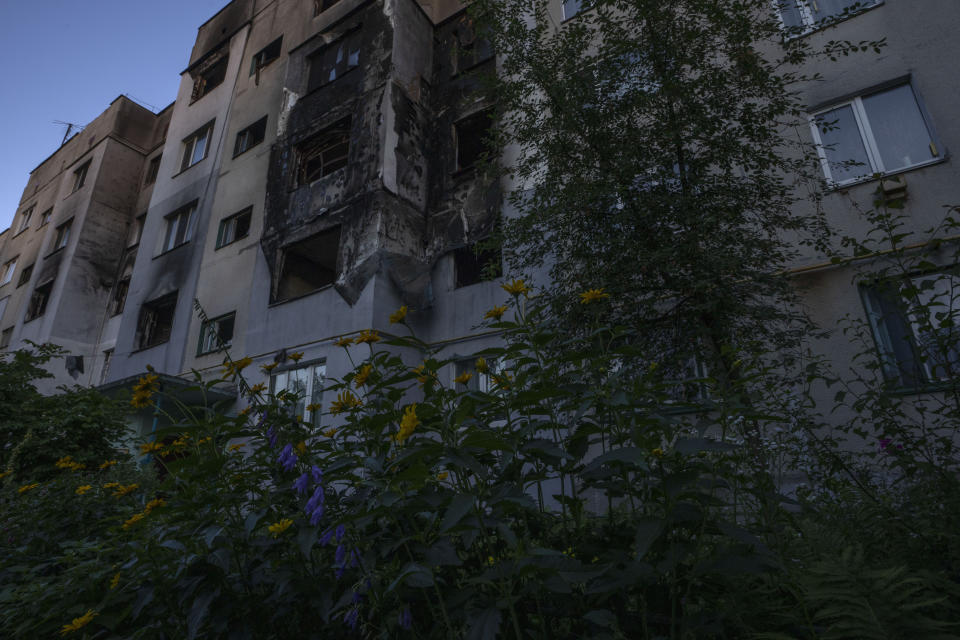 The war-damaged building from Russian aerial bombs, 70-year-old Valentyna Klymenko, who lives alone in her apartment, in Borodyanka, Kyiv region, Ukraine, Tuesday, June 28, 2022. Then Klymenko returns, alone, to an apartment that used to be noisy and full of life. Now, instead of the voices of her great-grandchildren, she is greeted by dim, damp rooms. She rarely cooks. She drinks fruit compote and eats canned tomatoes, which she prepared last year, so as not to waste the gas in her portable stove. (AP Photo/Nariman El-Mofty)