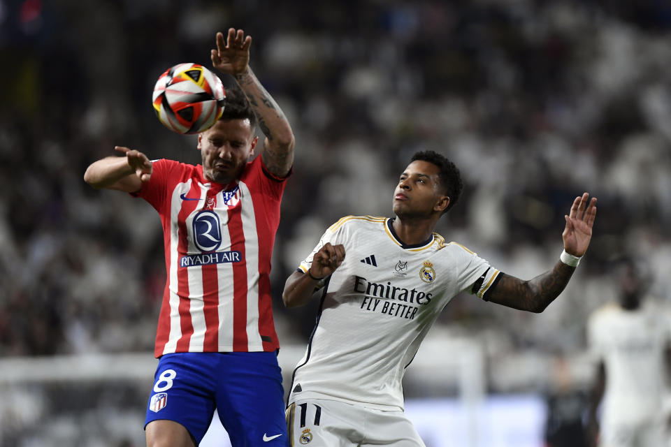 Real Madrid's Rodrygo, right, jumps for the ball with Atletico Madrid's Saul during the Spanish Super Cup semi final soccer match between Real Madrid and Atletico Madrid at Al Awal Park Stadium in Riyadh, Saudi Arabia, Wednesday, Jan. 10, 2024. (AP Photo)