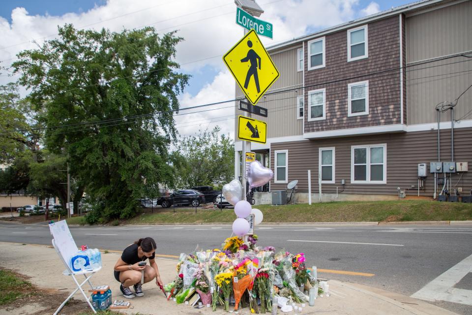 Emma Oliveras, a sophomore at Florida State University, lights a candle at the memorial created for Ellie Sims, a FSU student who was struck and killed by a driver earlier in the week, Wednesday, May 1, 2024.