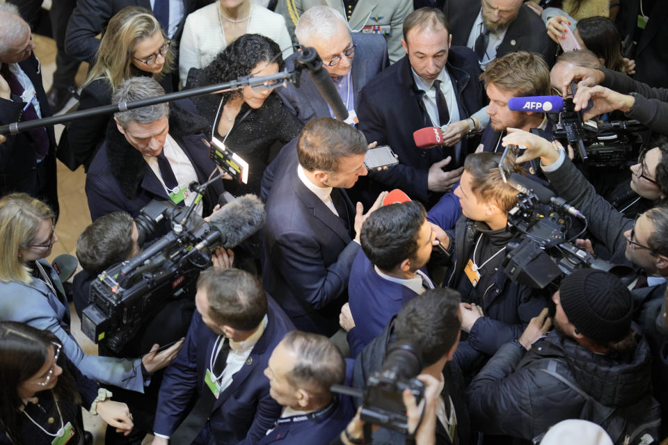 France's President Emmanuel Macron, centre, is surrounded by reporters before delivering his speech at the Annual Meeting of World Economic Forum in Davos, Switzerland, Wednesday, Jan. 17, 2024. The annual meeting of the World Economic Forum is taking place in Davos from Jan. 15 until Jan. 19, 2024.(AP Photo/Markus Schreiber)