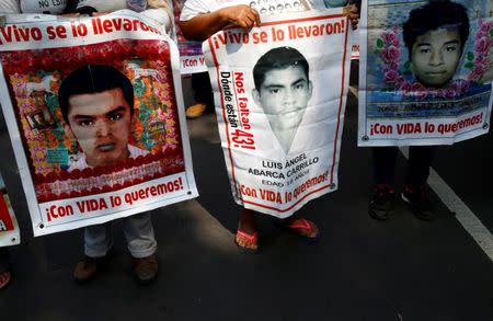 FILE PHOTO: Relatives hold posters with images of some of the 43 missing students of Ayotzinapa College Raul Isidro Burgos as they take part in a march to mark National Teachers' Day along Reforma avenue, in Mexico City, Mexico May 15, 2017. REUTERS/Henry Romero/File Photo