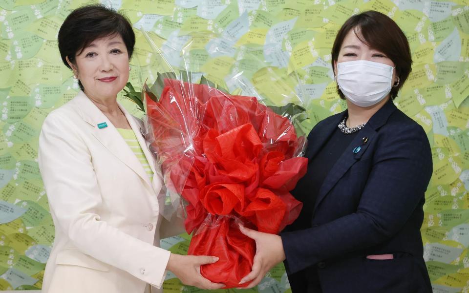 Tokyo governor Yuriko Koike receives a bouquet of flowers after her election win - AFP