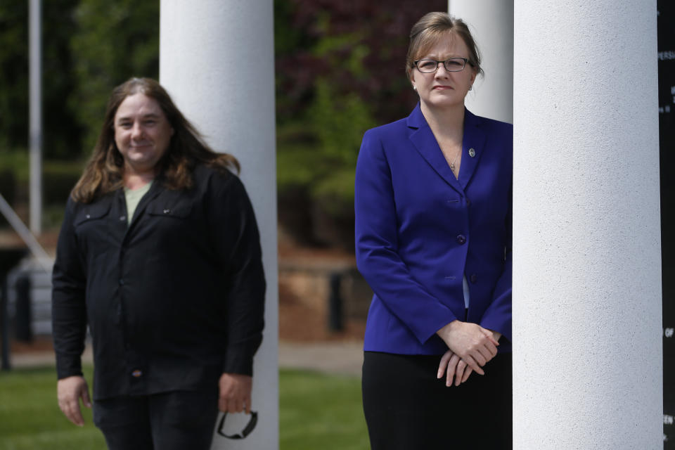 Halifax County Commonwealth's Attorney Tracy Martin, right, poses with Kevin Wynn at the Halifax County War Memorial on Wednesday May 6, 2020, in Halifax, Va. Martin has objected to the geriatric release of Debra Scribner, 66, convicted in 2012 of first-degree murder, conspiracy and a firearms charge in the death of her son-in-law, Eric Wynn, who was the brother of Kevin Wynn. A review by The Associated Press found during a push to accelerate the review of parole-eligible inmates because of the coronavirus pandemic, Virginia released dozens of violent offenders, including killers, rapists and kidnappers, blindsiding prosecutors and victims' families who say they were not properly notified as required by law. (AP Photo/Steve Helber)