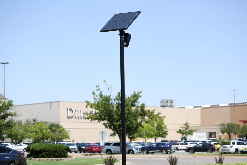 A Flock automatic license plate reader camera, owned by Penn Square Mall, stands near the south mall entrance. The city of Oklahoma City is adding 90 of its own Flock cameras on roadways and public areas.