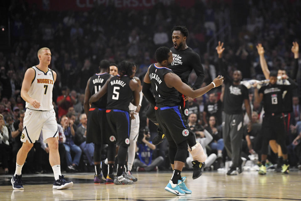 Los Angeles Clippers guard Reggie Jackson, center left, celebrates with guard Patrick Beverley, center right, after hitting a three-point shot as Denver Nuggets forward Mason Plumlee, left, walks toward his bench during the first half of an NBA basketball game Friday, Feb. 28, 2020, in Los Angeles. (AP Photo/Mark J. Terrill)