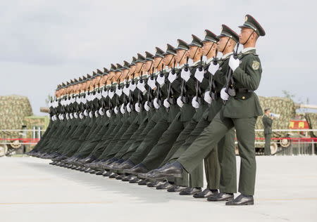 Soldiers of China's People's Liberation Army march with their weapons during a training session for a military parade to mark the 70th anniversary of the end of World War Two, at a military base in Beijing, China, September 1, 2015. REUTERS/Stringer