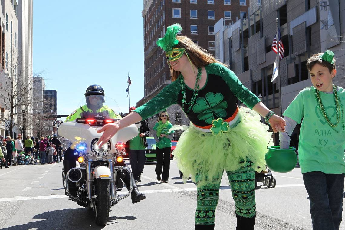 A woman threw chocolate gold coins to children Saturday during the Lexington St. Patrick’s Day Parade.