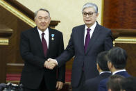 FILE - Kazakhstan's interim president Kassym-Jomart Tokayev, right, and outgoing Kazakh President Nursultan Nazarbayev shake hands after an inauguration ceremony in Astana, Kazakhstan, Wednesday, March 20, 2019. Nazarbayev resigned in 2019, but until recently remained head of the ruling Nur Otan party and chair of the Security Council. Tokayev, the chair of the upper house of parliament, was appointed president and renamed the capital of Astana to Nur-Sultan, to honor his predecessor. (AP Photo/File)