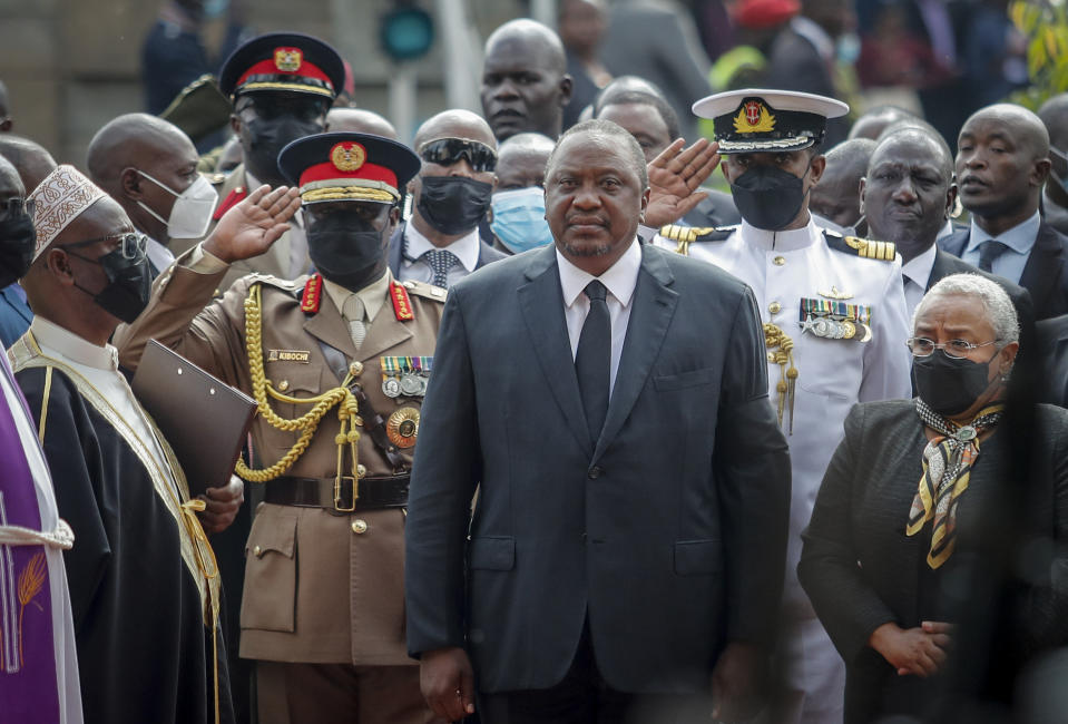 FILE - Kenya's President Uhuru Kenyatta, center, and his wife Margaret Kenyatta, right, arrive to view the body of former President Mwai Kibaki lying in state at parliament in Nairobi, Kenya on April 25, 2022. Kenya's Aug. 9 election is ripping open the scars of inequality and corruption as East Africa's economic hub chooses a successor to President Uhuru Kenyatta. (AP Photo/Brian Inganga, File)