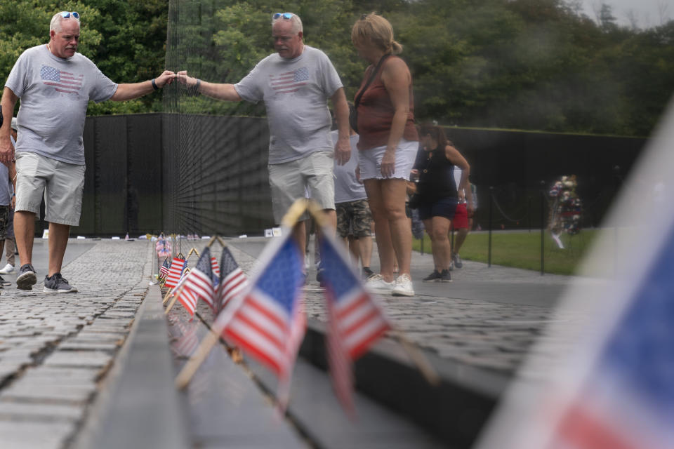 Doug James, with his wife, Joann James, of Union, Ky., touches the Vietnam Veterans Memorial, Monday, Sept. 19, 2022, during a visit to Washington. (AP Photo/Jacquelyn Martin)