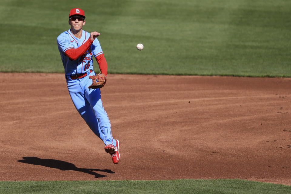 St. Louis Cardinals' Tommy Edman fields the ball and throws out Cincinnati Reds' Nick Castellanos at first base during the first inning of a baseball game in Cincinnati, Saturday, April 3, 2021. (AP Photo/Aaron Doster)