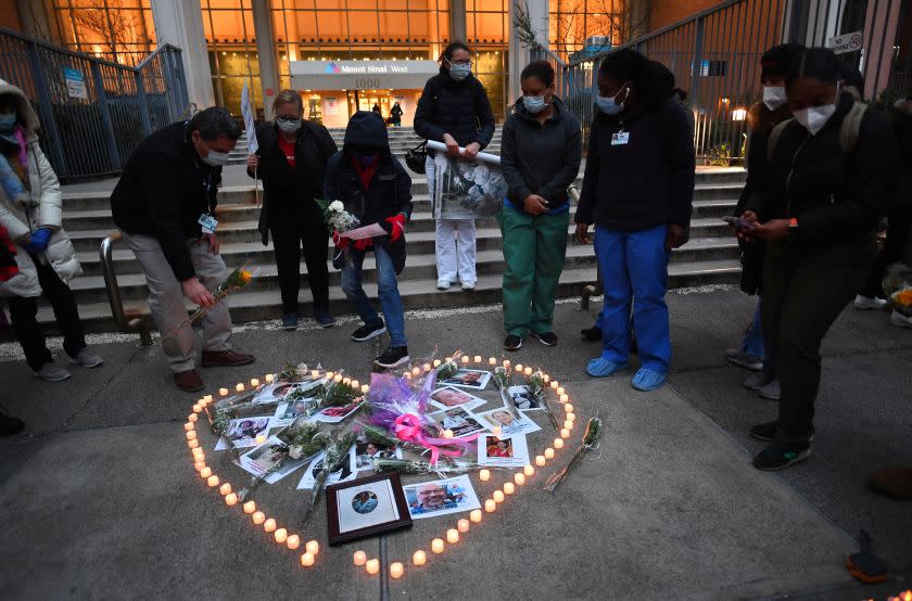 Nurses and healthcare workers light candles as they mourn and remember their colleagues who died during the outbreak of the novel coronavirus (which causes COVID-19) during a demonstration outside Mount Sinai Hospital in Manhattan on April 10, 2020 in New York City. - The global coronavirus death toll topped 100,000 on April 10 as Easter celebrations around the world kicked off in near-empty churches with billions of people stuck indoors to halt the pandemic's deadly worldwide march. (Photo by Johannes EISELE / AFP) (Photo by JOHANNES EISELE/AFP via Getty Images)