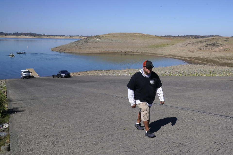 Anthony Kernan makes a long walk up the Folsom Lake boat ramp that is normally underwater, after docking at Folsom Lake in Folsom, Calif., Monday, Oct. 3, 2022. The reservoir is filled to about 70% of its historical average as California began its new water year that started Oct. 1. The past three years have been California's driest on record and state officials said that they're preparing for the streak to continue. (AP Photo/Rich Pedroncelli)