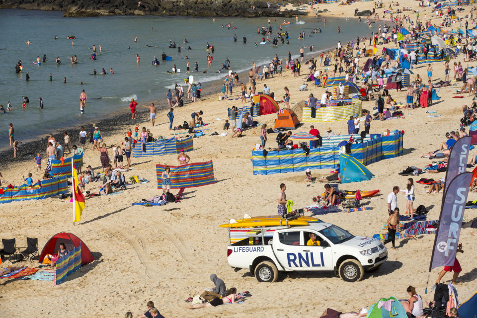 Holiday makers on the beach in St Ives, Cornwall, UK.