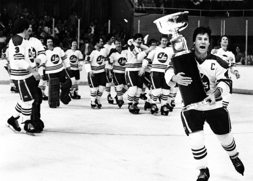 FILE - Winnipeg Jets captain Lars-Erik Sjoberg carries the Avco Cup after the Jets beat the Edmonton Oilers 7-3 to capture the final World Hockey Association (WHA) championship, four games to two, in Winnipeg, Manitoba, May 20, 1979. The American Basketball Association and World Hockey Association have been gone for decades, but their brash challenges to the set-in-their-ways NBA and NHL left a mark that is still recognizable today. (AP Photo/Canadian Press via AP)