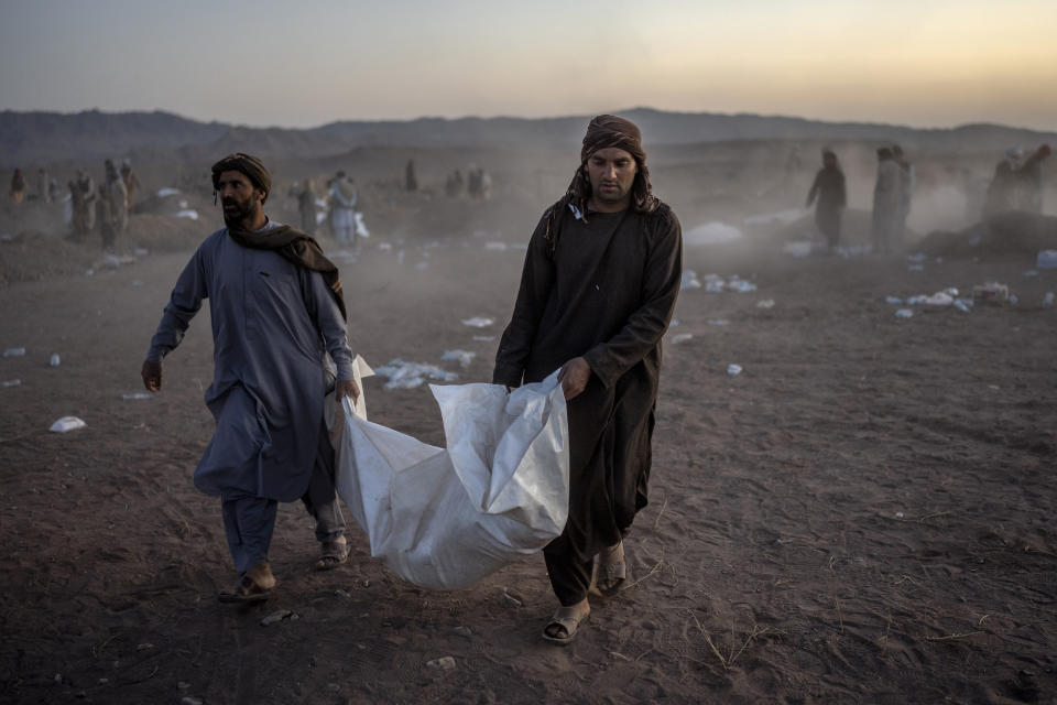 Afghan people carry the body of a relative killed in an earthquake at a burial site after an earthquake in Zenda Jan district in Herat province, western of Afghanistan, Monday, Oct. 9, 2023. Saturday's deadly earthquake killed and injured thousands when it leveled an untold number of homes in Herat province. (AP Photo/Ebrahim Noroozi)