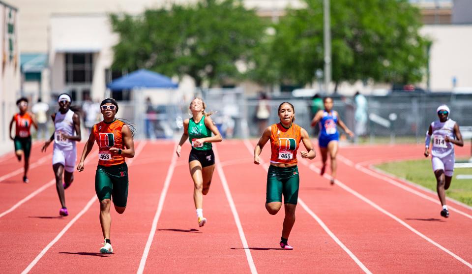 Dunbar’s Kayla Hopkins, center left, and Jasmine Jimenez sprint to the finish in the 400 meters at the Lee County Athletic Conference Championships at Dunbar High School on Saturday, April 9, 2022. Hopkins won and Jimenez was second. 