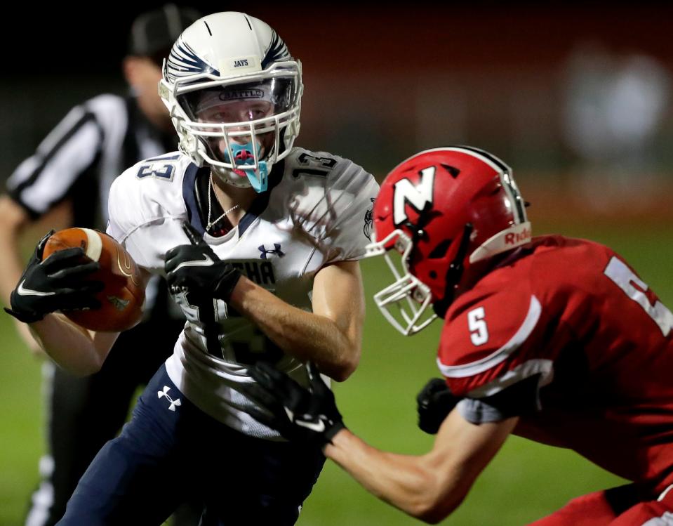 Menasha's Ty Schwartzkopf (13) runs against Neenah's Coy Rajotte during their game last season in Neenah.