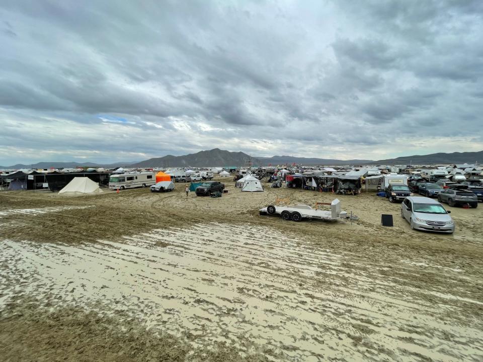 Camps are set on a muddy desert plain.
