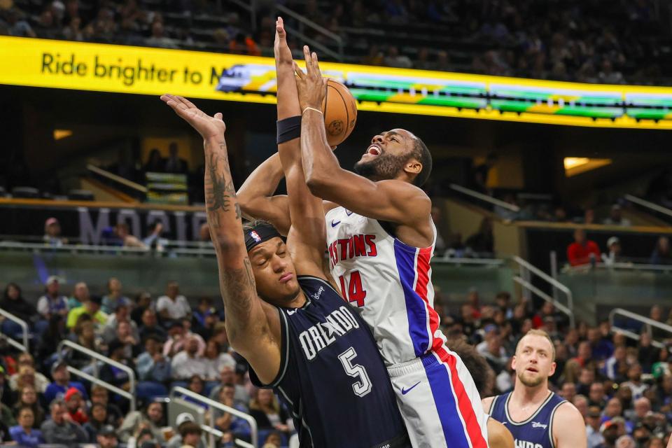 Pistons guard Alec Burks is fouled by Magic forward Paolo Banchero during the second half at Amway Center in Orlando, Dec. 8, 2023.