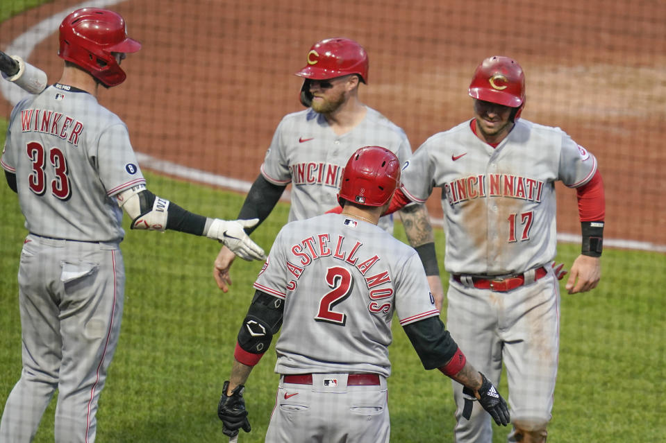 Cincinnati Reds' Kyle Farmer (17) and Tucker Barnhart, center, celebrate with teammates Jesse Winker (33) and Nick Castellanos (2) after scoring on a hit by Nick Senzel off Pittsburgh Pirates relief pitcher Duane Underwood Jr. in the fourth inning of a baseball game, Monday, May 10, 2021, in Pittsburgh. (AP Photo/Keith Srakocic)