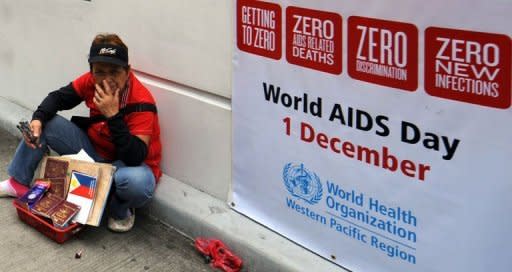 A vendor sits next to a world AIDS day poster displayed in front of the World Health Organization (WHO) regional office in Manila on December 1. The Philippines is struggling to deal with a worsening HIV-AIDS problem, with far too little money being spent on reversing a steady rise in infection rates, health experts warn