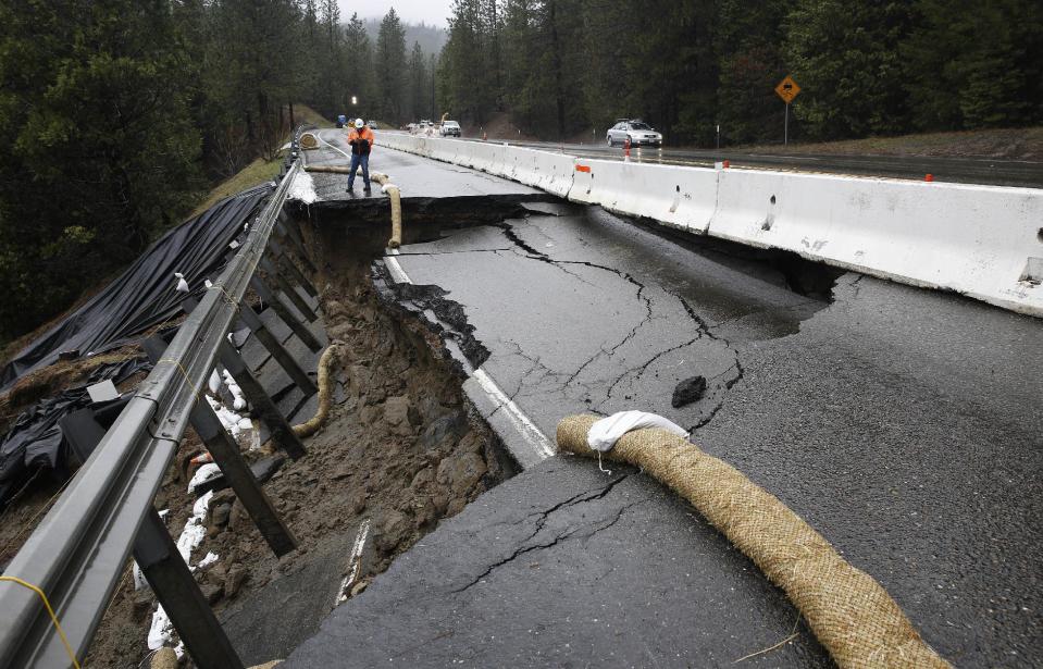 FILE--In this Feb. 21, 2017, file photo, the shoulder and one lane of westbound Highway 50 are damaged due to storms near Pollock Pines, Calif. The bill to repair California's roadways hammered by floods and rockslides in an onslaught of storms this winter is already at least $550 million, more than double what the state budgeted for such emergencies. (AP Photo/Rich Pedroncelli, file)