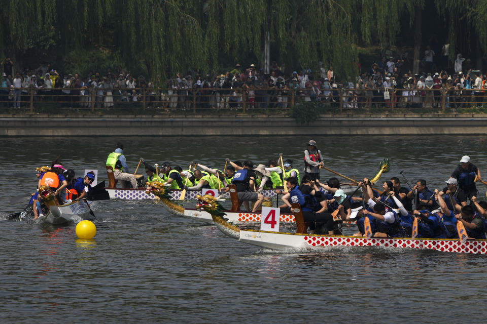 Competitors take part in a race during the Dragon Boat Festival at a canal in Tongzhou, outskirts of Beijing, Monday, June 10, 2024. The Duanwu Festival, also known as the Dragon Boat Festival, falls on the fifth day of the fifth month of the Chinese lunar calendar and is marked by eating rice dumplings and racing dragon boats. (AP Photo/Andy Wong)