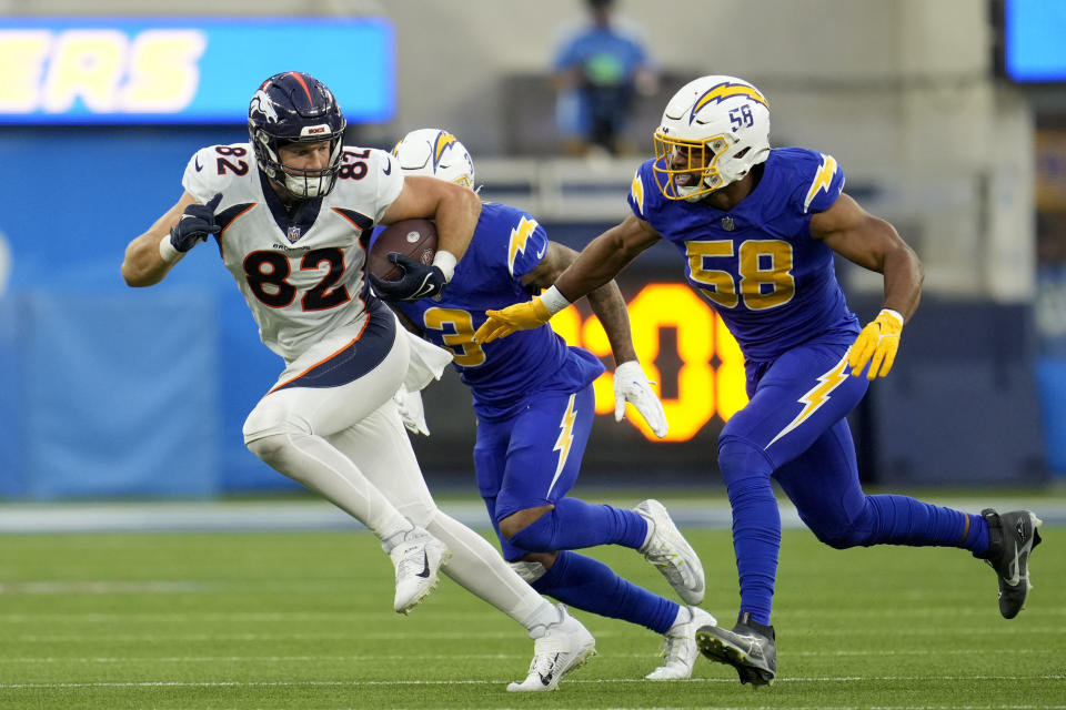 Denver Broncos tight end Adam Trautman (82) carries the ball as he is followed by Los Angeles Chargers linebacker Justin Hollins (58) during the second half of an NFL football game Sunday, Dec. 10, 2023, in Inglewood, Calif. (AP Photo/Marcio Jose Sanchez)